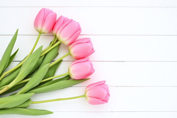 bunch of pink tulips on a white wooden surface