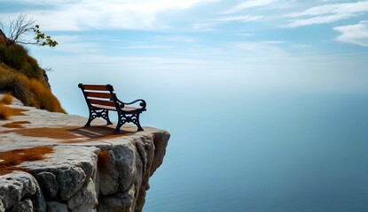 An empty bench on a cliff edge with beautiful blue sky background