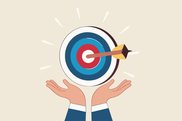 Goal or target, focus and concentration to achieve success, purpose or objective, aiming at target bullseye, accuracy, challenge and aspiration, businessman hand hold target with arrow hit bullseye.