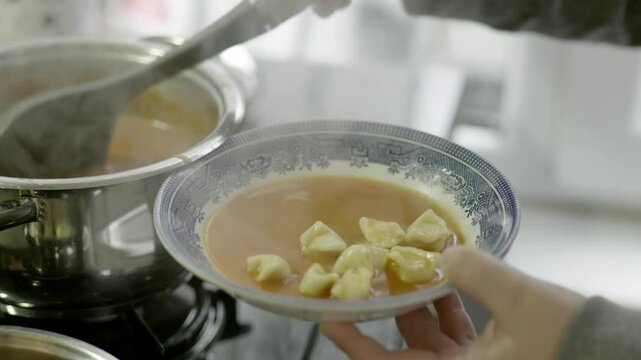 traditional Turkish dish manti soup is placed on a plate
