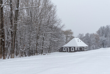 Naklejka premium Winter landscape with an old Romanian traditional wooden house covered in deep snow