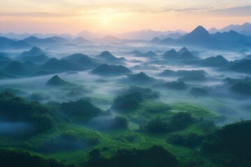 Fototapeta premium Misty sunrise over lush green terraced rice fields in a mountain range.