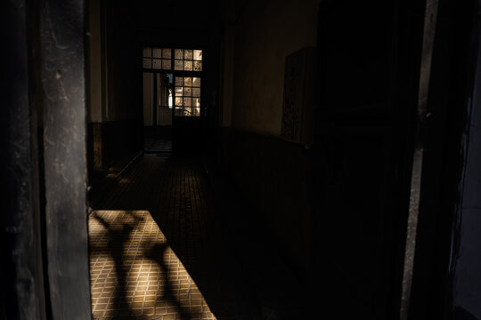 Dimly lit hallway with sunlight and shadows in an urban building - Powered by Adobe