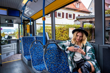 Relaxed woman text messaging while traveling by bus in Stuttgart, Germany.