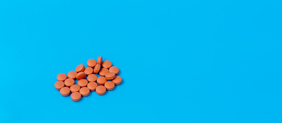 Pile of Brown Round Pills on Blue Background