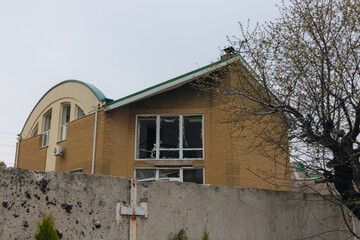 Civilian population. Consequences of shelling of a residential building in Ukraine. Destroyed roof, broken windows and traces of an explosion. Details of the destruction of a residential building