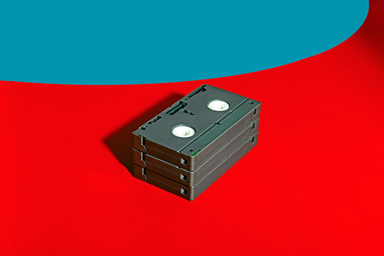Stack of VHS cassettes on a vibrant red and blue background