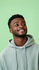 Fototapeta premium Radiant Outlook: A young man's cheerful demeanor and captivating gaze, set against a vibrant green backdrop, embodies hope and positivity.