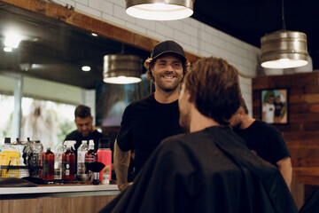 Barber cutting young man's hair in salon
