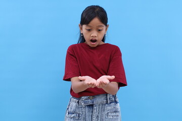 Wow and amazed expression of asian little girl while holding something on her hands