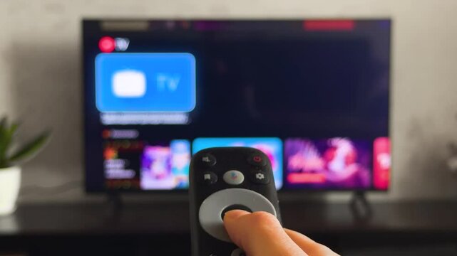 Person watch modern tv pov. Cozy living room large television displaying show, movie, film program. Woman hand holds remote control close up. Home entertainment. First point of view. Streaming service