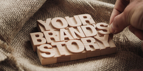 Close-up of wooden letters spelling "Your Brand's Story" on burlap, showcasing brand identity and narrative, ideal for marketing or storytelling concepts