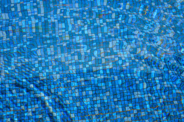 Swimming pool water surface and ripple wave with blue mosaic tiles