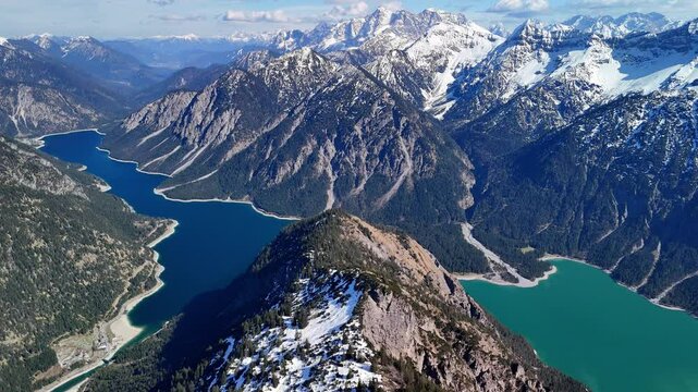 Aerial drone view of the beautiful Plansee Lake and Heiterwanger See Lake, located in the Austrian Alps. A view of crystal-clear waters, a sunny day and majestic mountains all around. 