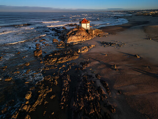 Aerial view of the beautiful chapel Capela do Senhor da Pedra in Portugal as seen during the sunrise.