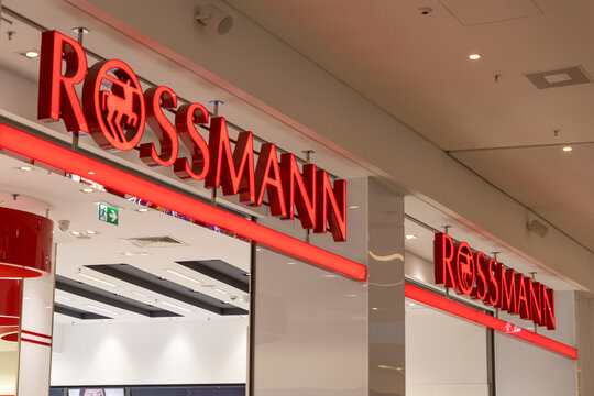 Poznan, Poland - March 22, 2025: Rossmann store front with bright red illuminated logo and modern interior design inside shopping mall, showcasing recognizable pharmacy and beauty retail chain