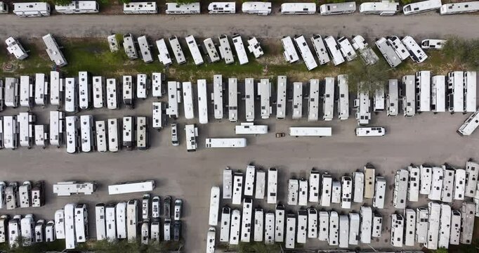 Dealers outdoor parking lot with many brand new travel trailers and campervans in stock for sale. Concept of development of American RV automotive industry.