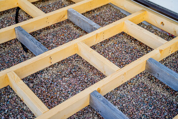 image of the process of building a terrace, wooden planks are fastened together, sand and gravel lie on the ground, neat construction