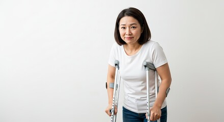 Asian Woman Using Crutches for Mobility After Injury or Surgery