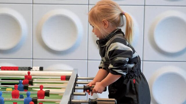 Little child girl plays kicker foosball. Saint Petersburg, Russia - 6 Apr 2025