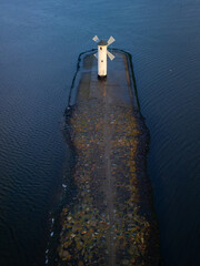 Pier with the lighthouse in northern Poland during early morning.