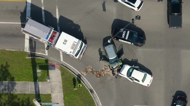 First responders responding to car accident site on American street. Emergency services helping victims of vehicle crash on road in USA.