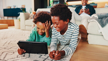 Siblings, tablet and African children in home with smile, care and video games for online...