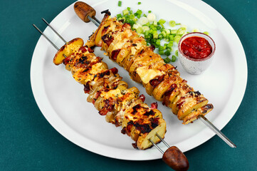 Potatoes with bacon on skewers, summer barbecue.
