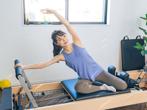 マシンピラティスのトレーニングをする女性