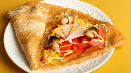 thin pancakes with tomato and cheese filling. serving salty food on yellow background. Thin pancakes with fillings