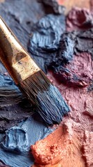 Palette with mixed colors, a paintbrush resting atop of the vibrant swirls