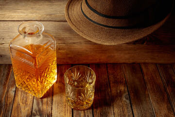 Elegant whiskey glass and decanter on a old wooden table.