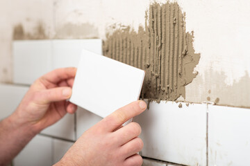 Facing walls with decorative tiles, laying white tiles