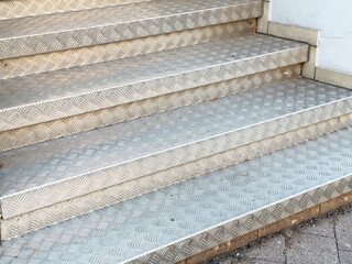 Metallic checker plate outdoor stairs with geometric pattern and texture