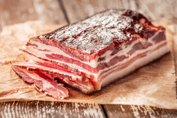 Black Forest ham, bacon on wooden kitchen table, dry cured pork