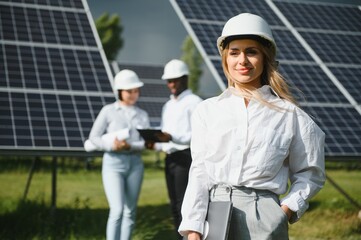 Male and female engineers worker working in solar panels power farm. technician working at solar power station