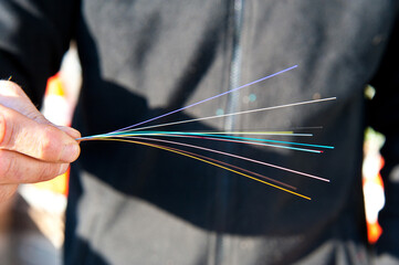 un main de technicien tenant un faisceau de fibres optiques