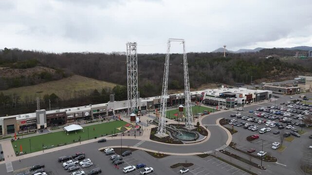 Aerial rotating shot of a bungee jump in a shopping plaza in Piegon Forge, TN.