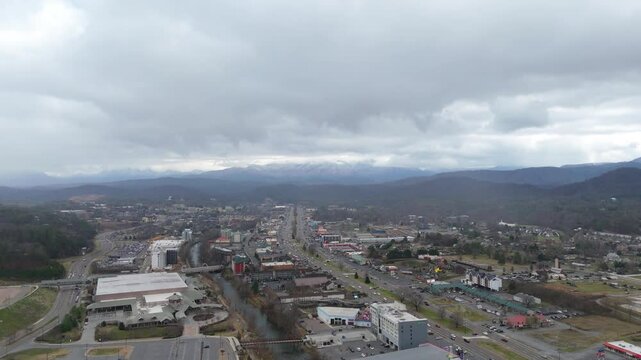 Aerial shot of Piegon Forge, TN on January 1st 2025 with snow covered Smoky Mountains in the background.