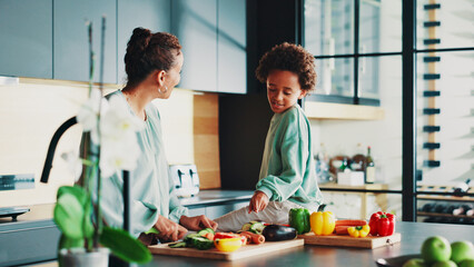 Mother, boy and happy with cooking in kitchen, home and learning for diet with vegetables, bonding and support. People, mom and child with point, food and teaching with nutrition in family house