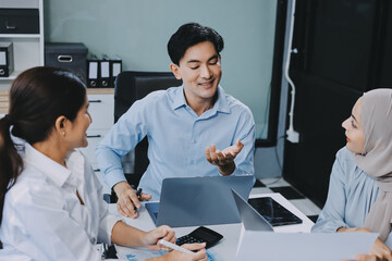 Diverse international executive business partners group discuss report at boardroom meeting table. Multiracial team negotiating project developing business strategy doing paperwork analysis in office.