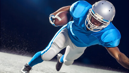 football player in blue uniform lunges forward while holding football, showcasing determination and athleticism
