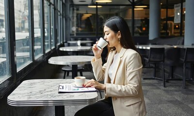 Woman Drinking Coffee Reviewing Document in Cafe Setting