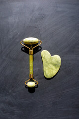 Quartz Jade roller and Gua Sha set on dark backround, daily face care routine, face massage 