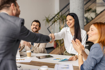 Fototapeta premium Friendly businesswoman having handshake with team member in boardroom.