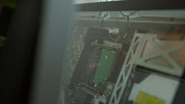 Tracking shot of intricate internal components of nettop computer, showcasing complexity of motherboard, hard drive, cooling system, electronics, close-up, nobody, no people, slow motion.