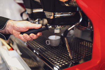 Close up of professional barista using coffee espresso machine.