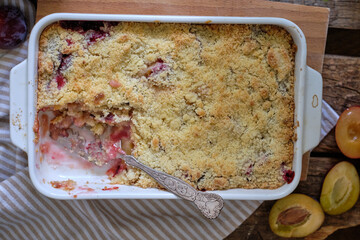 Plum streusel pie. Top view, wooden background, rustic.