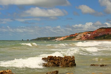 Green waters of a tropical beach in northeastern Brazil, with waves breaking water edge, sunny day, summer vacation at Tabatinga beach, Joao Pessoa.