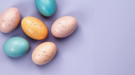 Various pastel colored easter eggs are arranged on a light purple surface